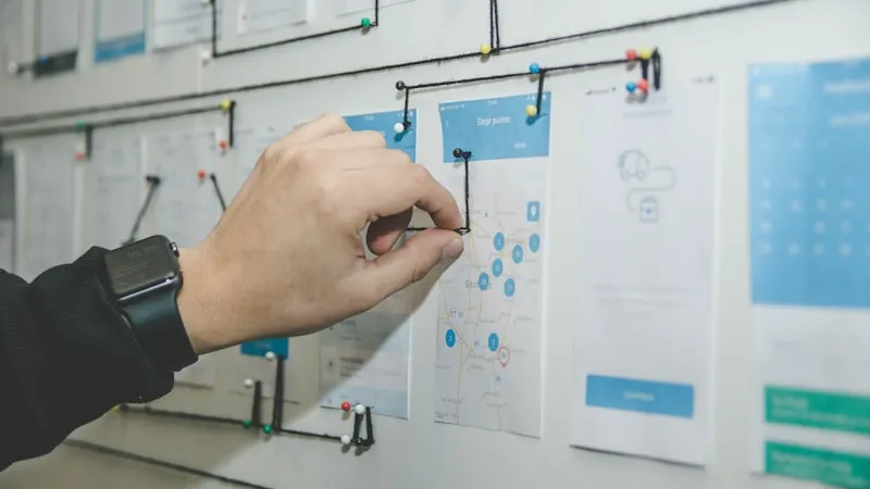 Workflow pinned to a wall with connecting strings, illustrating the multi-step case study production process