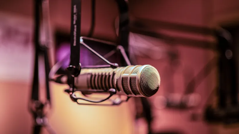 A studio microphone in warm light, representing the recorded customer interview that becomes verifiable, machine-readable proof.